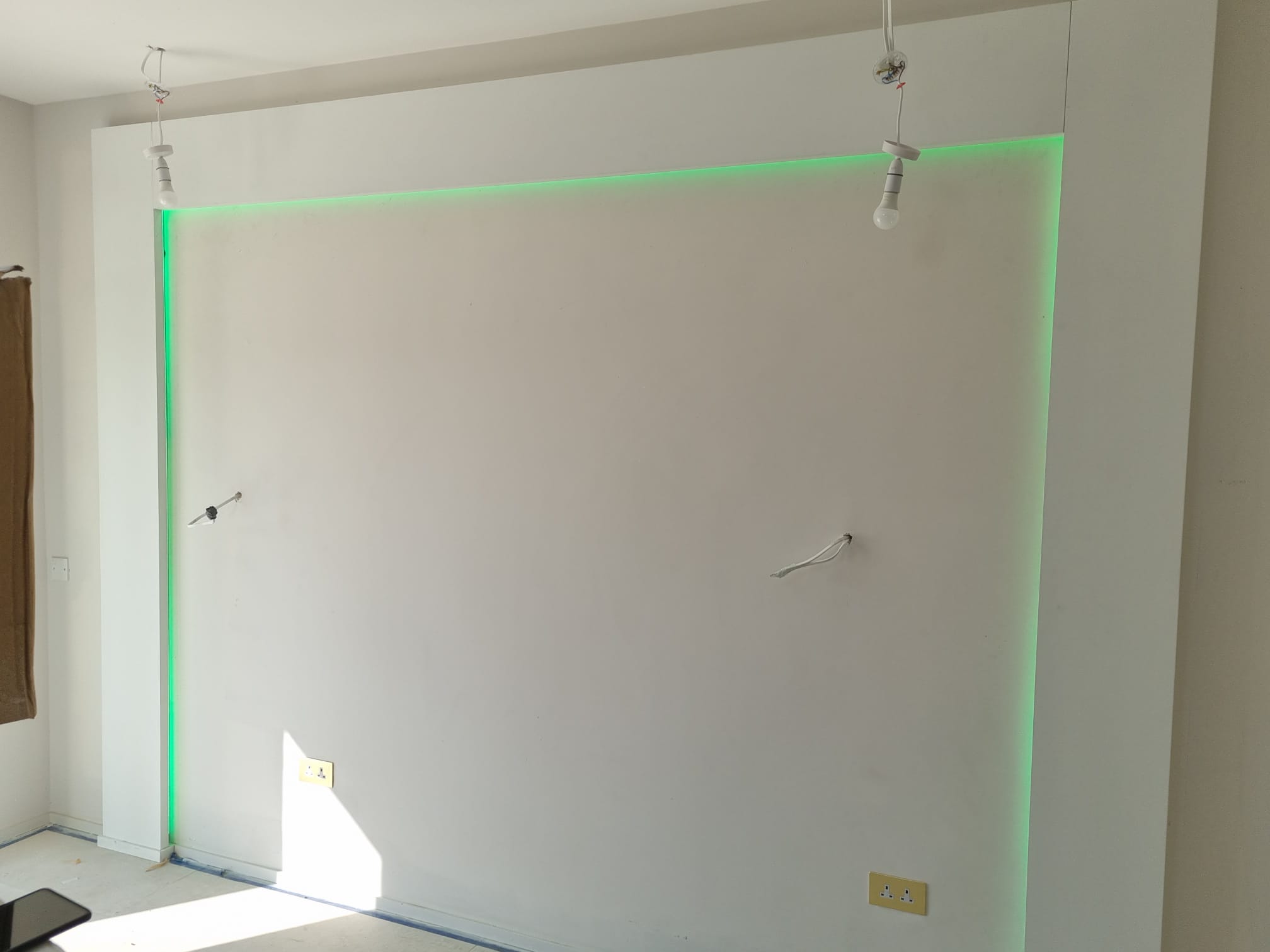 Green LED strip lighting on a white wall